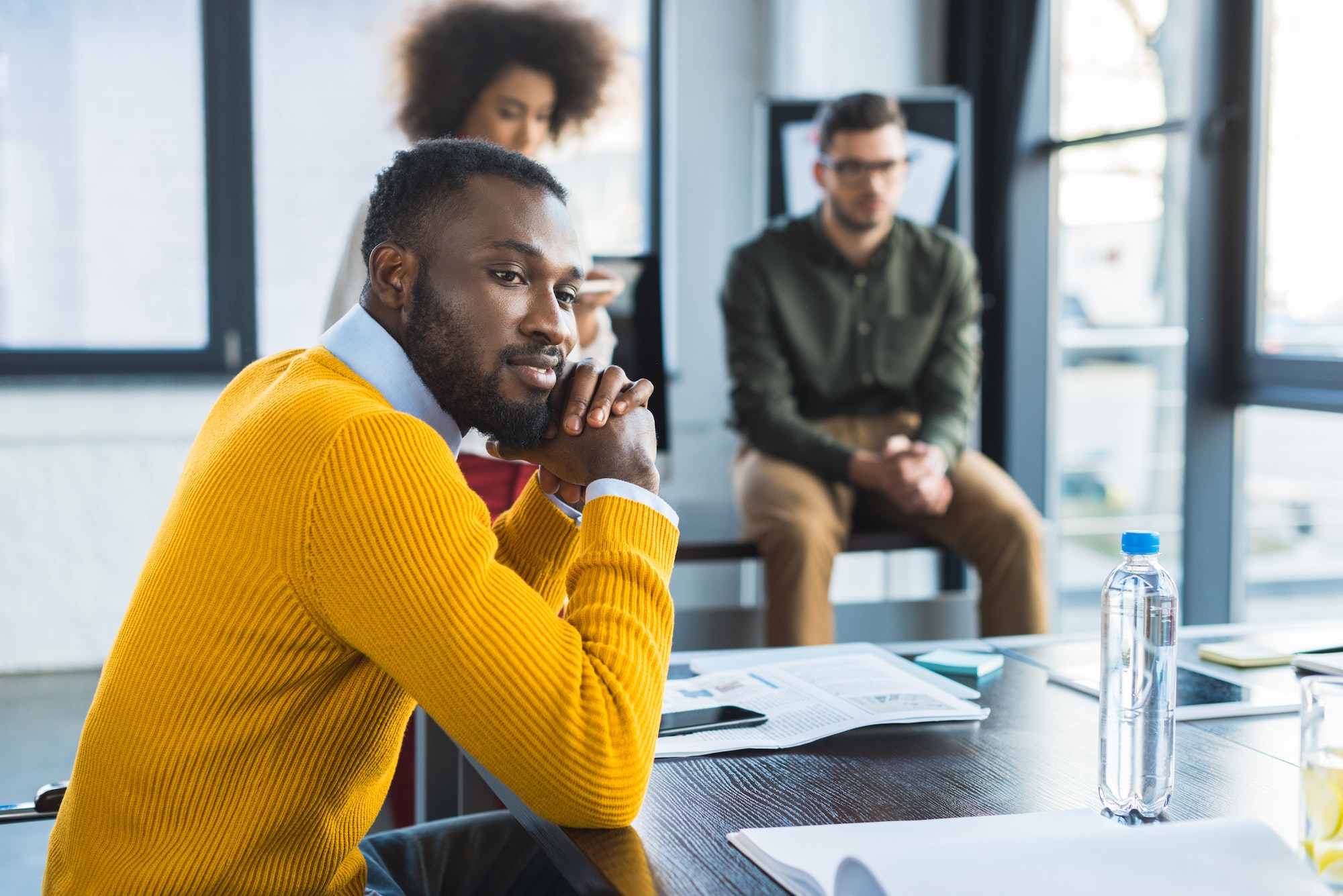 side view of pensive african american businessman at meeting in office